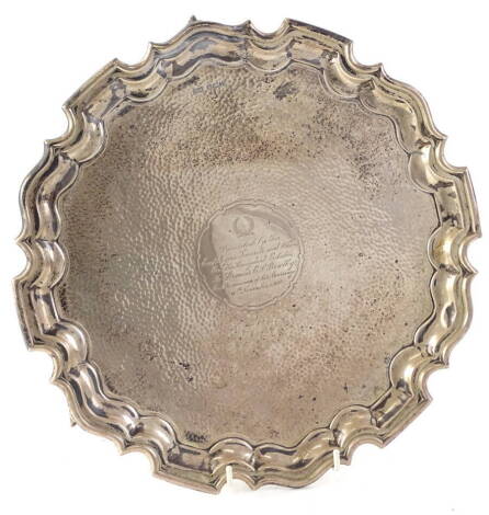 A George V silver salver, with a shaped border and hammered decoration overall, engraved centrally with a laurel wreath and inscribed "presented by the employees tenants and others on the Knoydart Estate to Francis E J Bowlby on the occasion of his marria