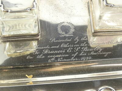 A George V silver presentation ink stand, of rectangular form with a shaped edge and two glass square section wells, engraved "presented by the employees tenants and others on the Knoydart Estate to Francis E J Bowlby on occasion of his marriage 6th Septe - 2