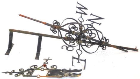 A wrought iron weather vane, the top mounted with a stylised flag and pointer, 163cm high. By family repute, holes to top, possibly caused by a Zeppelin.