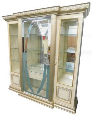 An Arredo Italian simulated marble and parcel gilt breakfront display cabinet, the top with a foliate and rope twist cornice above two part mirrored glazed doors, enclosing glass shelves, etc., flanked by two further doors, part glazed and panelled on a p