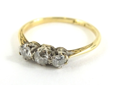 A three stone diamond dress ring, set with three tiny old cut diamonds, on a thin yellow metal band, ring size J, 1.6g all in.