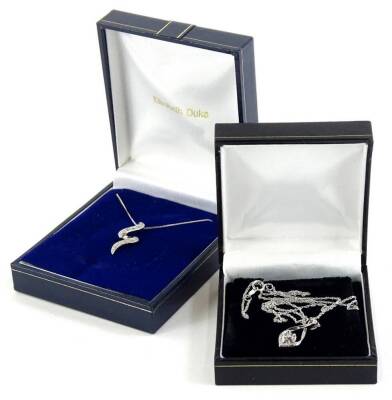 Two modern pendants and chains, to include a silver crossover pendant and chain, set with tiny white paste stones, together with a 9ct white gold drop pendant set with white coloured stones, on a fine link chain, 2.1g (2, boxed).