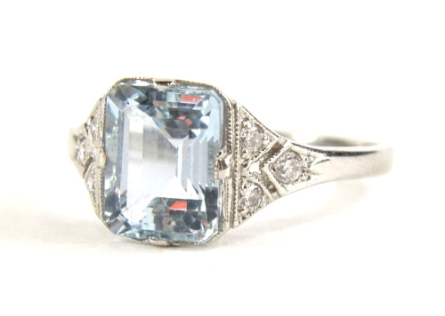 An Art Deco style aquamarine and diamond ring, set with rectangular cut aquamarine 8.8mm x 6.8mm x 5mm, with three round brilliant cut diamond shoulders, in a raised basket setting, white metal, stamped platinum, ring size O½, 4.4g all in, boxed.