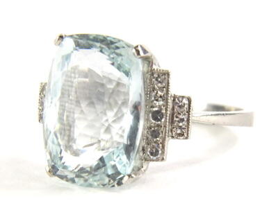 An aquamarine and diamond dress ring, set with central aquamarine 14.4mm x 10.6mm x 7.8mm, totalling approx 8.6cts overall, in raised four claw basket setting, with two layered diamond set shoulders, the first layer with five round brilliant cut diamonds,