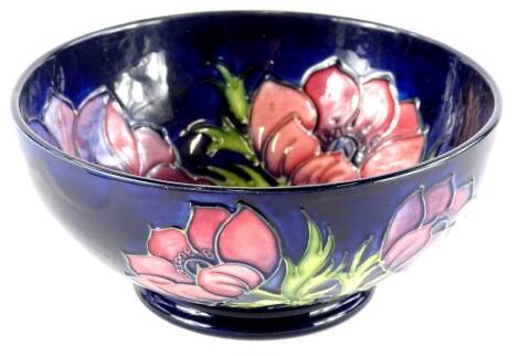 A Moorcroft pottery bowl, decorated with poppies, on a navy blue ground, impressed mark to underside, numbered 34/94, 15cm diameter.