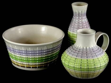 Three items of Bourne Denby stoneware, each decorated with bands of green, purple and brown and highlighted with black and white, a flask vase and a bowl.