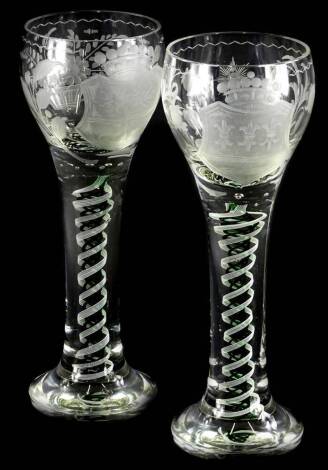 A pair of large glass goblets, each engraved with a crest and with an opaque and green twist stem, with tapering foot, possibly continental , 28.5cm high.
