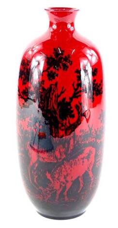 A Royal Doulton Woodcut flambe vase, decorated with deer, in dark navy, on a red ground, 27cm high.