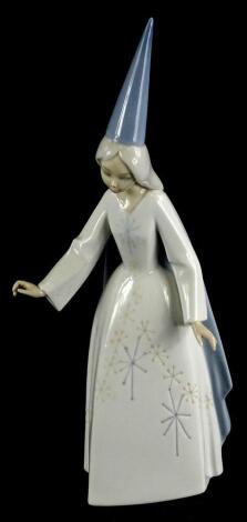 A Lladro porcelain figure of a young witch, numbered to underside 5495, 27cm high (boxed).