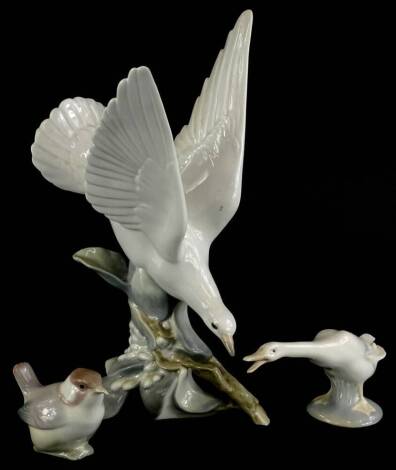 Three Lladro birds, to include a dove, seated on a branch of blossom, a wren and a goose.