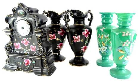 A late 19thC Staffordshire pottery clock garniture, comprising mantel clock decorated with roses on a black and gilt ground and a pair of two handled vases, each stamped Albany Vase, the clock with associated movement, 31cm high and a pair of Victorian gr