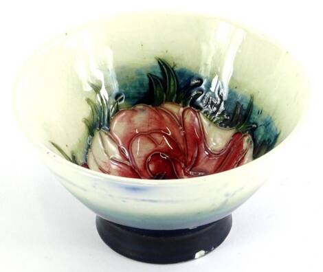 A Moorcroft pottery flared bowl, decorated centrally with an anemone on a cream and navy blue ground, incised and impressed mark to underside, 10.5cm diameter.