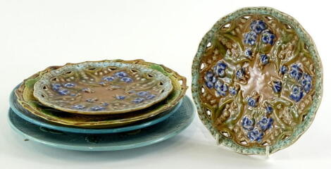 A collection of Majolica dessert dishes, to include one decorated with fruit on a turquoise ground, another similar, a leaf moulded plate, two dessert plates with pierced borders.