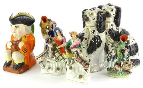 A collection of Staffordshire, to include a Toby jug, decorated with an orange coat etc., 23cm high, a pair of spaniels and four figure groups.