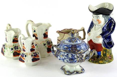 A collection of 19thC pottery, to include a Toby jug with cobalt blue coat and red trousers, 25cm high, a graduated set of three Masons type jugs, a lustre jug and a blue and white tureen (AF).