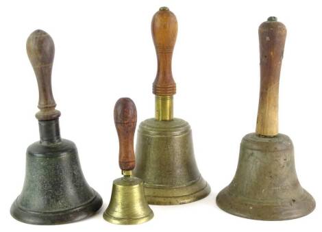 Four brass bells, each with a turned wood handle, the largest 27.5cm high.