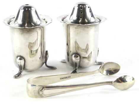 A collection of silver plate, to include a pepper pot and matching salt pot and a set of sugar tongs. AUCTIONEER ANNOUNCE : Not silver, silver plate.