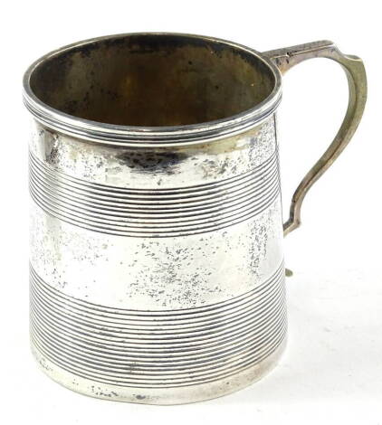 An Edward VII silver cylindrical christening mug, with reeded decoration and shaped handle, inset to the underside with a George IV silver coin, inscribed Joan Catherine Trotter from her Uncle Edward H Trotter, Charterhall Xmas 1909, London 1908, 4½oz.