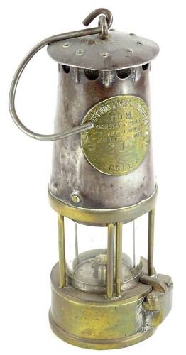 A steel and brass miner's lamp, the plaque numbered 210, 23cm high.