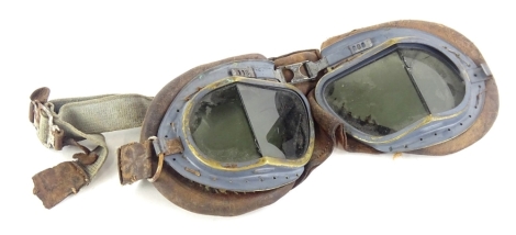 A pair of flying goggles, grey painted onto a brass, with leather coated padding, glass (AF).