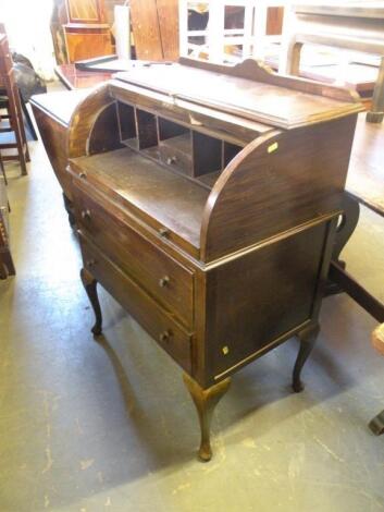 An oak cylinder bureau with two drawer on cabriole legs