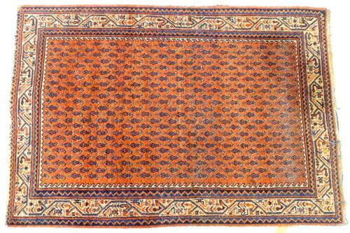 A Persian rug, with a design of botei, on a red ground with one wide and two narrow borders, 103cm x 146cm.