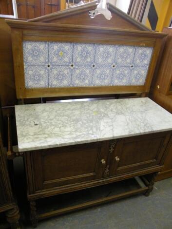 An oak wash stand, the raised back with blue printed tiles on