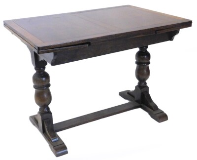 An oak draw leaf dining table, with a rectangular top on turned end supports, with low flat stretcher, the top 75.5cm x 106cm enclosed.