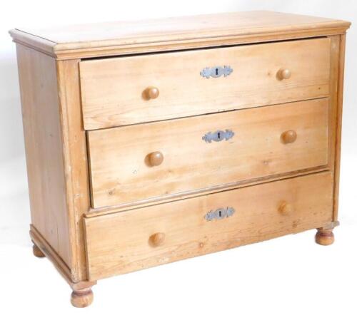 A 19thC continental stripped pine chest of drawers, the top with a moulded edge above three long drawers, each with turned wood handles on bun feet, 102cm wide.