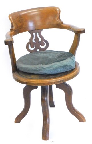 A Victorian walnut office chair, with a shaped back and pierced splat and a circular leather padded seat, on splayed legs.