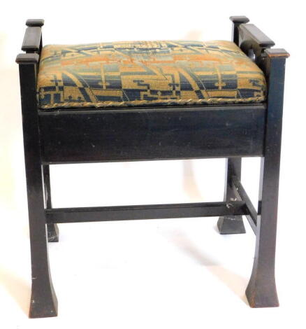 A late 19thC gothic style piano stool, with a hinged top, on tapering legs.