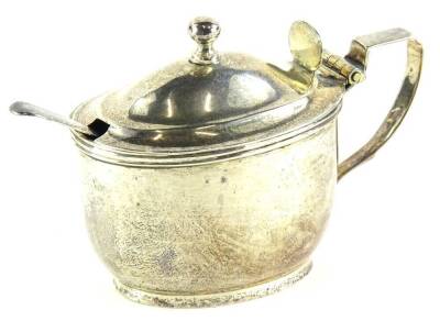 A George V silver oval mustard pot, with blue glass liner, angular handle, London 1921, an associated spoon, weighable silver 4½oz.