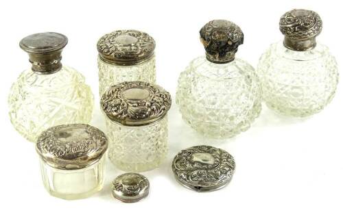 A collection of cut glass and silver mounted scent bottles, to include three globular examples, three jars, etc., to include two lids.