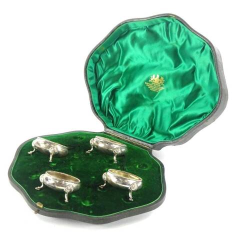 A cased set of four Victorian silver open salts, Mappin Bros. case, each with an upper bead border, with plain circular sections, on shell capped triple hoof feet, London 1898, 5.5cm diameter, 4.1/2oz (4, cased).