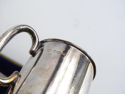 A George V silver christening set, comprising cylindrical tapering mug, knife, fork, napkin ring and a small label for ketchup, in a fitted case, hallmarks for Sheffield 1912 etc. - 2