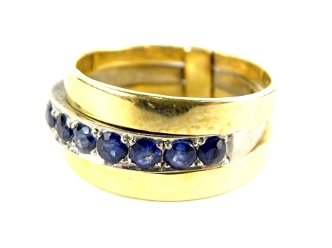 A three ring design single dress ring, with central platinum band, set with sapphires, with two outer coloured yellow metal bands, unmarked, ring size R, 8.4g all in.