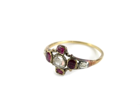 A Victorian dress ring, set in star design, with old cut central diamond, surrounded by four garnets, in thin yellow metal setting, ring size M, misshapen, 1.6g.