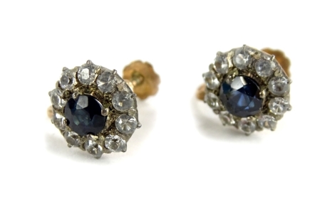 A pair of Victorian style cluster screw on earrings, each set with central pale blue stone, surrounded by white stones, in a white metal setting on a yellow metal back, unmarked possibly silver gilt, 3.2g all in.