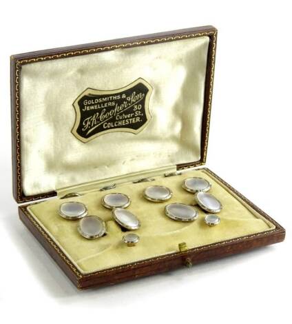 A gentleman's collar tie and cufflinks set, each set with mother of pearl panel, surrounded by white metal border, on yellow metal backs, stamped 9ct, comprising a pair of cufflinks, two collar studs, and four shirt studs, in presentation case.