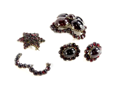 Victorian and later garnet set jewellery, comprising a Victorian garnet brooch, with four large circular garnets, surrounding by a frame of smaller stones (AF), in a silver gilt setting, with single pin back, a star two layered brooch (AF) and a pair of a