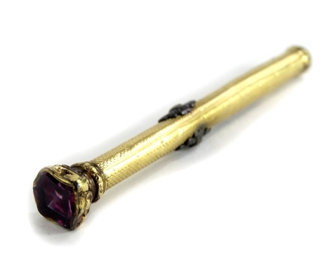 A Victorian 9ct gold pencil case, set with shield shaped single amethyst stone to top, with engine turned decoration and heavily scrolled decoration to top 9cm long, 17g all in.