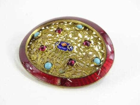 An Eastern buckle brooch, the original oval buckle with red enamel surround (AF), with later floral insert set with turquoise garnet and enamel decoration, gilt metal, unmarked 6cm x 5cm.