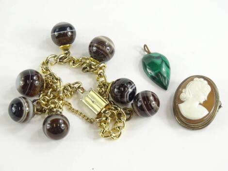 Three items of jewellery, comprising a silver framed cameo brooch, a malachite tear-drop design pendant, with yellow metal pendant loop, and a bullseye agate gold plated bracelet (3).