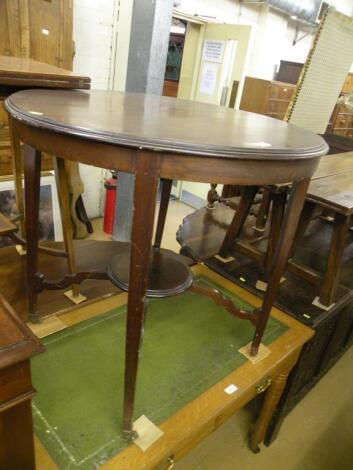 An Edwardian circular two tier occasional table on brass castors<br