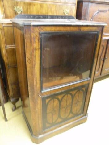 A Victorian walnut pier cabinet with a glazed door above an inlaid