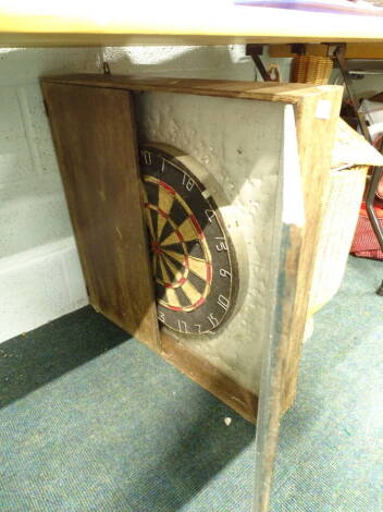A dartboard, in fitted oak surround.