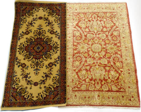 A modern Ziegler rug, with an all over design of flowers, leaves, etc., in cream on a red ground, 119cm x 176cm and a machine woven rug (2).