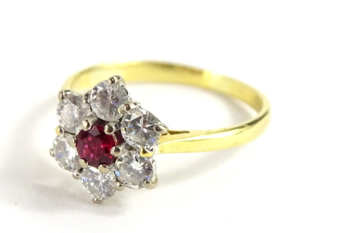 An 18ct gold ruby and diamond cluster ring, with central ruby 3.2mm diameter, surrounded by six round brilliant cut diamonds, estimated overall carat weight 1ct, all stones set in a white claw setting, on a yellow metal 2mm shank, London 1987, ring size P
