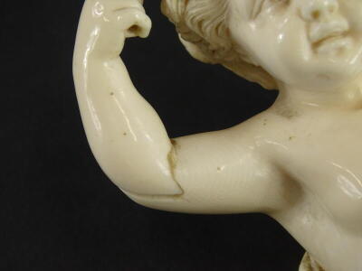 A 19thC carved ivory putto, the head carved with flowers and leaves, lacking wings, etc., 16cm high. - 2
