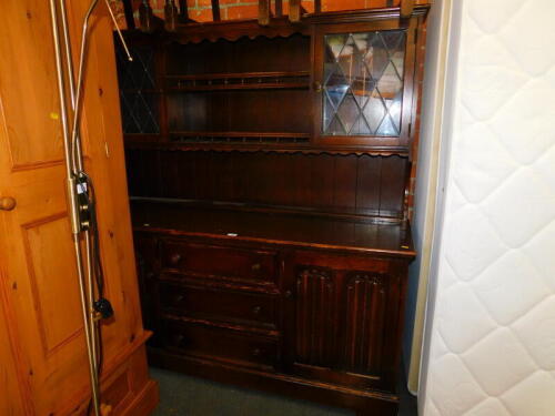 An oak kitchen dresser, with two glazed doors, open shelves above two linen fold carved doors and three drawers, 165cm high, 164cm wide, 50cm deep.